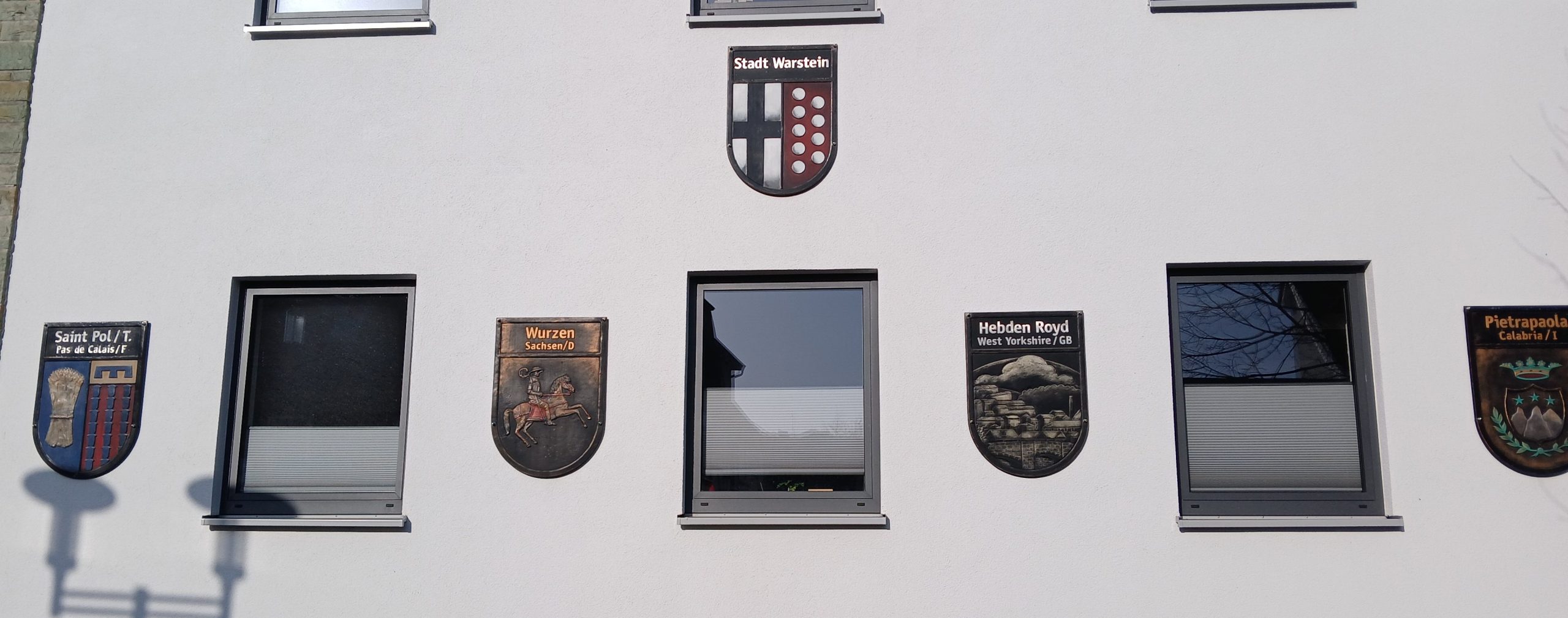 Rathaus Warstein mit dem Wappen der Stadt Warstein und den Partnerstädten
